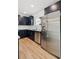 Modern kitchen featuring stainless steel appliances, sleek dark cabinetry, and stylish wood-look tile flooring at 13405 Sw 88Th Ter # 53, Ocala, FL 34473