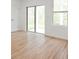 Bright living space with sliding glass doors, wood-look tile flooring, and a white door in the corner at 13405 Sw 88Th Ter # 53, Ocala, FL 34473