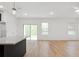 Bright living space with sliding glass doors, wood-look tile flooring, and kitchen island in the background at 13405 Sw 88Th Ter # 53, Ocala, FL 34473