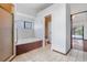 Bright bathroom features a soaking tub, a small window, and an open doorway at 13542 Texas Woods Cir, Orlando, FL 32824