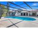 Backyard with pool and enclosed screened in patio and view of home at 13542 Texas Woods Cir, Orlando, FL 32824