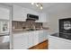 Well-lit kitchen features white cabinets, a microwave, and mosaic backsplash at 1407 Lantry Ct, Orlando, FL 32804