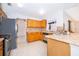 Traditional kitchen featuring oak cabinets, stainless steel appliances, tile backsplash, and flooring in neutral tones at 142 Barrington Dr, Kissimmee, FL 34758