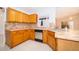 Traditional kitchen featuring honey oak cabinets, light tile countertops, and stainless steel appliances at 142 Barrington Dr, Kissimmee, FL 34758