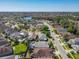 Wide aerial view of a residential area with a lake, community pools, and homes at 14228 Portrush Dr, Orlando, FL 32828