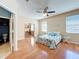 Main bedroom with wood floors, ceiling fan, and doorway into bathroom at 14228 Portrush Dr, Orlando, FL 32828