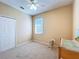 This carpeted bedroom features a ceiling fan, window with blinds, and closet at 14228 Portrush Dr, Orlando, FL 32828