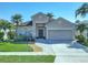 Inviting single-story home featuring a well-manicured lawn, garden, and a convenient two-car garage at 14228 Portrush Dr, Orlando, FL 32828