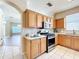 Well-lit kitchen featuring stainless steel appliances, light wood cabinets, and sleek countertops at 14228 Portrush Dr, Orlando, FL 32828