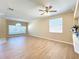 Inviting living room featuring light wood floors, neutral walls, crown molding, and large windows at 14228 Portrush Dr, Orlando, FL 32828