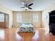 Well-lit bedroom with hardwood floors, ceiling fan, and coastal-themed decor at 14228 Portrush Dr, Orlando, FL 32828