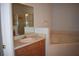 Bright bathroom featuring a vanity with sink, large mirror, soaking tub, and glass-enclosed shower at 1457 Waukon Cir, Casselberry, FL 32707