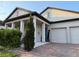 Close up of front elevation showing a covered porch with columns and a brick paver driveway at 14675 Scott Key Dr, Winter Garden, FL 34787