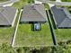 Aerial view of backyard with a screened hot tub, surrounded by a well-kept lawn and white fence at 149 St Thomas Dr, Mulberry, FL 33860