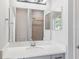 Well-lit bathroom vanity features a large mirror and a shower visible in the reflection, creating depth at 149 St Thomas Dr, Mulberry, FL 33860