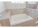 Close-up of a bathtub and shower featuring decorative tile at 149 St Thomas Dr, Mulberry, FL 33860