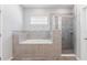 This is a well lit bathroom with a tiled tub and a glass enclosed shower at 149 St Thomas Dr, Mulberry, FL 33860