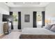 Bright bedroom with tray ceiling, two windows, and large television at 149 St Thomas Dr, Mulberry, FL 33860