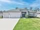 Beautiful single-story home with a three-car garage and manicured landscaping at 149 St Thomas Dr, Mulberry, FL 33860