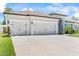 Exterior view of a three-car garage with white doors and a concrete driveway at 149 St Thomas Dr, Mulberry, FL 33860