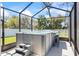 Relaxing in-ground hot tub with bar top and bar stools, enclosed in screened-in patio at 149 St Thomas Dr, Mulberry, FL 33860