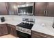 Modern kitchen with stainless steel appliances, white countertops, and dark cabinets at 149 St Thomas Dr, Mulberry, FL 33860