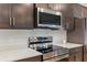 Modern kitchen featuring stainless steel appliances, dark wood cabinets, and white countertops at 149 St Thomas Dr, Mulberry, FL 33860