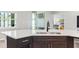 Kitchen island features a sink, dark cabinets, and quartz countertops at 149 St Thomas Dr, Mulberry, FL 33860