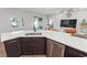Kitchen boasting a white quartz island, dark wood cabinetry, and stainless steel appliances in an open-concept living space at 149 St Thomas Dr, Mulberry, FL 33860