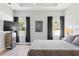 Well-lit main bedroom featuring wood floors, ceiling fan, and large windows with curtains at 149 St Thomas Dr, Mulberry, FL 33860