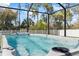 Relax in this screened-in pool with views of the lush backyard and blue skies at 149 St Thomas Dr, Mulberry, FL 33860