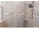 Close up of tile shower with new shower head, shower caddy, and tiled walls at 149 St Thomas Dr, Mulberry, FL 33860