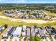 An aerial view showcases beautiful homes next to a golf course and lush trees at 1523 Corolla Ct, Reunion, FL 34747