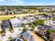 Aerial view of houses surrounded by lush greenery, with a golf course winding through the community at 1523 Corolla Ct, Reunion, FL 34747