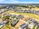 Aerial view of homes in a golf community with manicured lawns and beautiful landscaping at 1523 Corolla Ct, Reunion, FL 34747