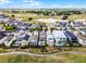 Aerial view showcasing homes with private pools bordering a picturesque green golf course at 1523 Corolla Ct, Reunion, FL 34747