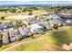 Aerial view showcasing homes with pools adjacent to a golf course, framed by mature landscaping and a vibrant community setting at 1523 Corolla Ct, Reunion, FL 34747