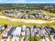 Expansive aerial view of a community with luxury homes nestled next to a golf course and lush greenery at 1523 Corolla Ct, Reunion, FL 34747