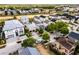 An aerial view showcasing a residential area with well-maintained homes, green landscaping, and a beautiful golf course in the background at 1523 Corolla Ct, Reunion, FL 34747