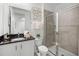 Elegant bathroom featuring a sleek vanity, granite countertop, and modern shower with glass door at 1523 Corolla Ct, Reunion, FL 34747
