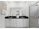 Bathroom featuring double sink vanity with black countertops and a glass-enclosed shower at 1523 Corolla Ct, Reunion, FL 34747