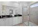 Bathroom featuring double sink vanity with black countertops and a glass-enclosed shower at 1523 Corolla Ct, Reunion, FL 34747