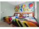 Themed bedroom with two twin beds, colorful Mickey Mouse bedding, and unique wall art at 1523 Corolla Ct, Reunion, FL 34747