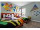 Themed bedroom with two twin beds, colorful Mickey Mouse bedding, and unique wall art at 1523 Corolla Ct, Reunion, FL 34747