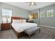 Well-lit bedroom with a bed, bench, a wooden desk, and views from two sunny windows at 1523 Corolla Ct, Reunion, FL 34747
