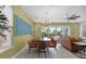 Open-concept dining area with a large wooden table and seating for eight, with artwork at 1523 Corolla Ct, Reunion, FL 34747