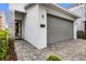Beautiful home exterior with stone accents, gray garage door, and manicured landscaping at 1523 Corolla Ct, Reunion, FL 34747