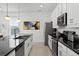 Modern kitchen with granite countertops, stainless steel appliances, and white cabinetry at 1523 Corolla Ct, Reunion, FL 34747