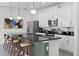 Modern kitchen featuring a central island with bar seating, stainless steel appliances, and pendant lighting at 1523 Corolla Ct, Reunion, FL 34747