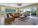 Stylish living room with a comfortable leather sofa, ceiling fan, and access to outdoor area at 1523 Corolla Ct, Reunion, FL 34747